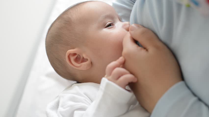 Newborn baby breastfeeding close up